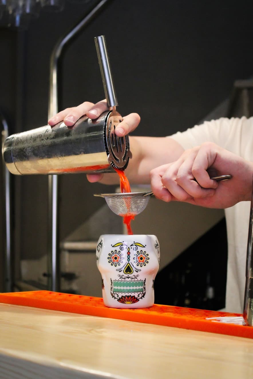 Cocktail being poured into tiki mug